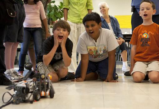 Building a sumo warrior block by block - LEGO® programmers, from left, Aidan Marinelli, Jose Pagan, and Luke Taylor watch as their team's robot is attacked by a competitor. It was a sumo-style robotic battle.