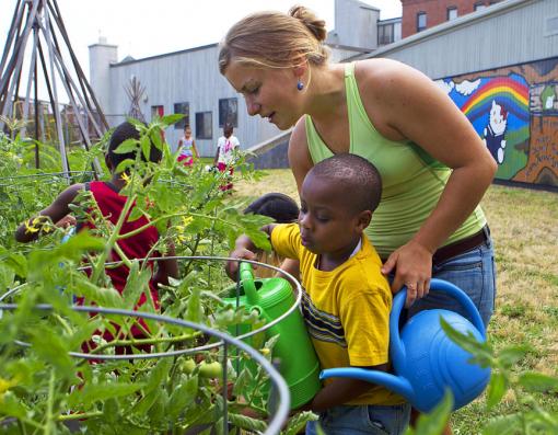 How — and why — does the garden grow? - Rising senior Mary Alice Reilly helps a young gardener give the plants a drink at the John Hope Settlement House. At Swearer Center projects like this, the learning is constant and effective — for preschoolers and Brown students alike.