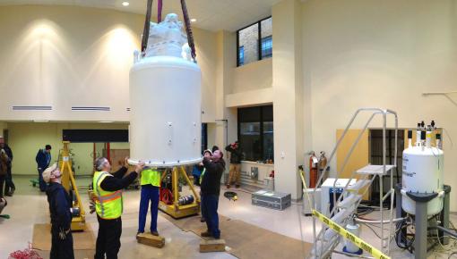 The only way in - Workers guide a 3.8-ton, $2.9-million magnet as it is lowered through the roof into place at the Structural Biology Core Facility. The new magnet is almost twice as powerful as the University’s earlier instrument, to the right. (View the crane’s eye video below.)