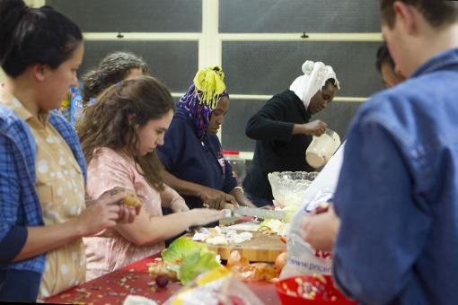 Many hands make light dinner - Participants in the Swearer Center’s Winter Break Project join members of a local Eritrean family whose children are tutored by Brown students to prepare a meal for the whole group.