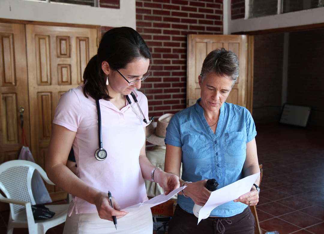 “We exist to serve the poor”: Brown doctors and students visit a few times a year, but Honduran health care providers run day-to-day operations. The Gauchipilincito clinic now has a full-time nurse, community health promoter and educator, and a security guard. Emily Harrison confers with Jodi Roque, a family medicine house staff officer at Memorial Hospital.