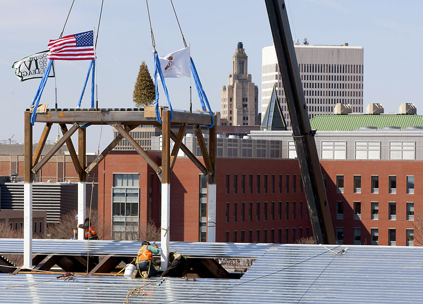 History in the making: The final piece of structural steel arrived with traditional flags and a Christmas tree. It will support the cupola that was preserved when the old Marvel Gymnasium was demolished. Credit: Mike Cohea/Brown University.