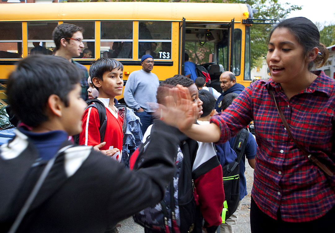 Fun by the bagful: Anahi Garcia ’14 high-five’s departing D’Abate School students, who boarded buses and rode off with bags of loot.