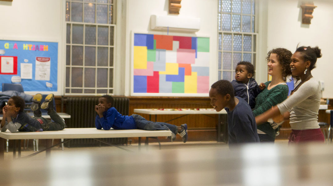 Refugee youth tutoring: Senior Sabine Adrian, a student project leader in the Refugee Communities group, watches a slideshow with children she tutors through the Brown Refugee Youth Tutoring and Enrichment Program. Credit:&nbsp;Mike&nbsp;Cohea/Brown&nbsp;University