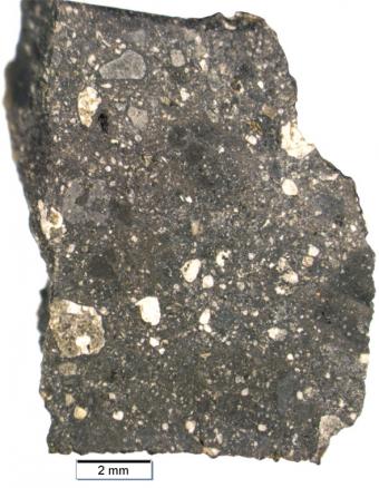 A chip from “Black Beauty,” a meteorite from Mars, contains different rock types welded together. It helps explain the Martian “dark plains,” large areas of the planet’s surface that have only a thin layer of red dust.